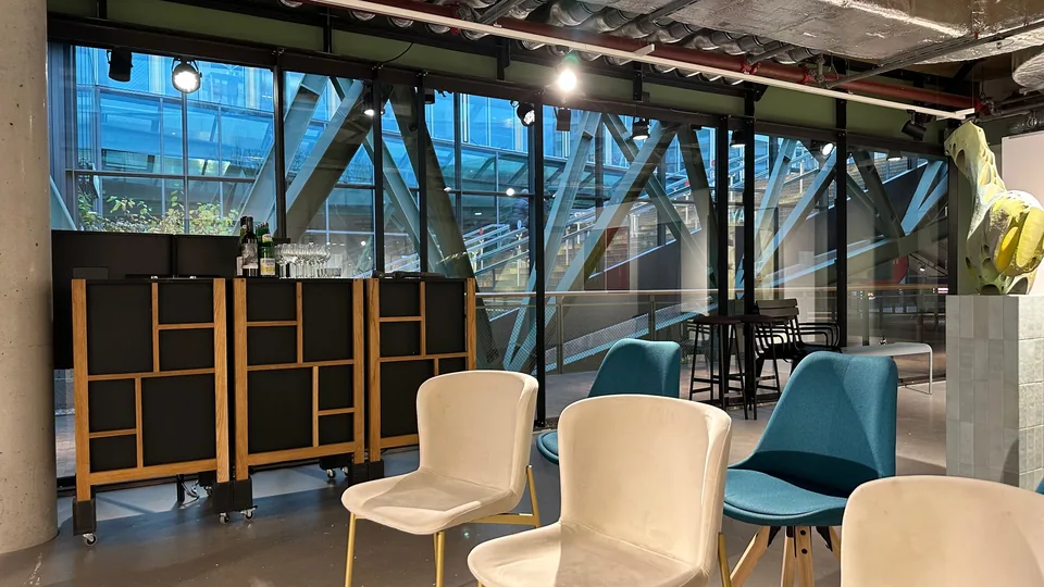 Bar furniture and chairs in front of the glass facade of the Bikini Berlin building